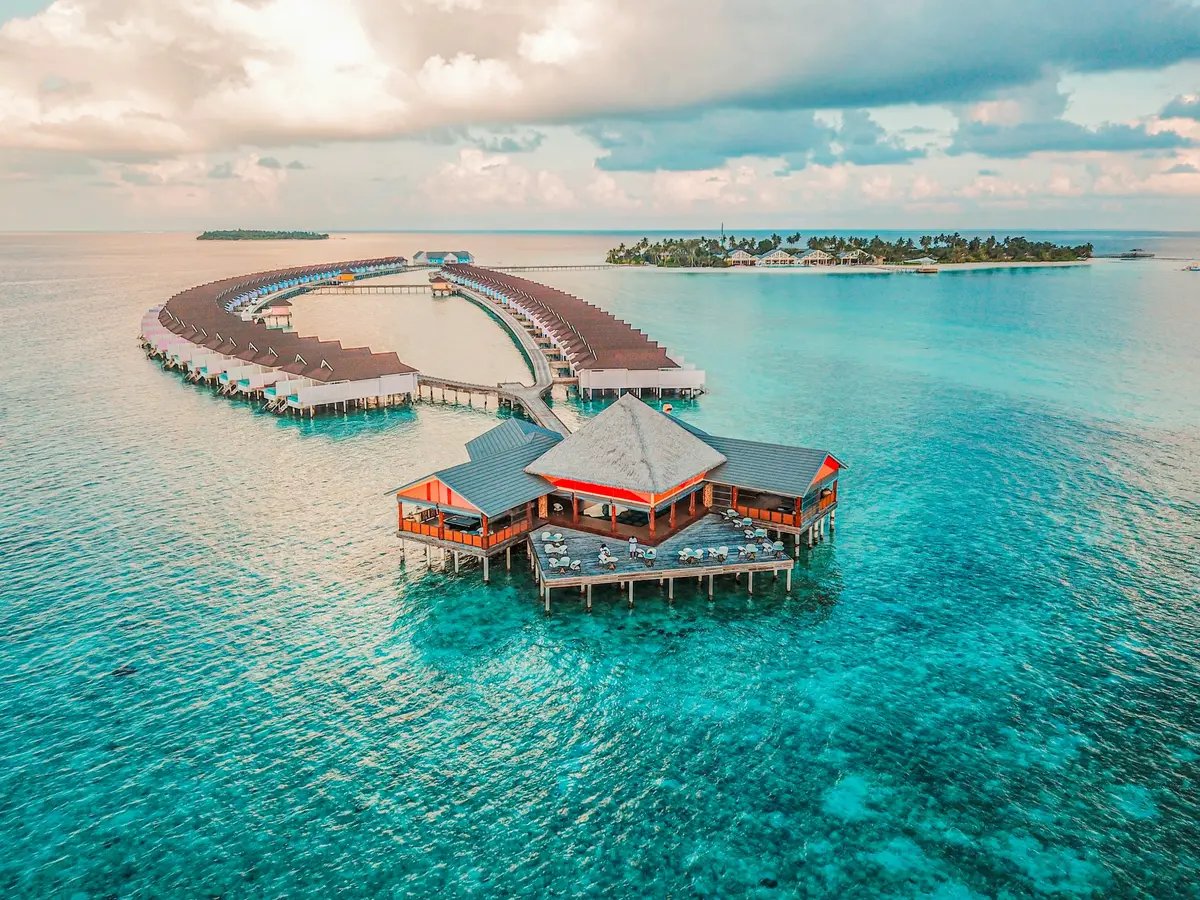 Overwater villas and a restaurant on turquoise water in the Maldives