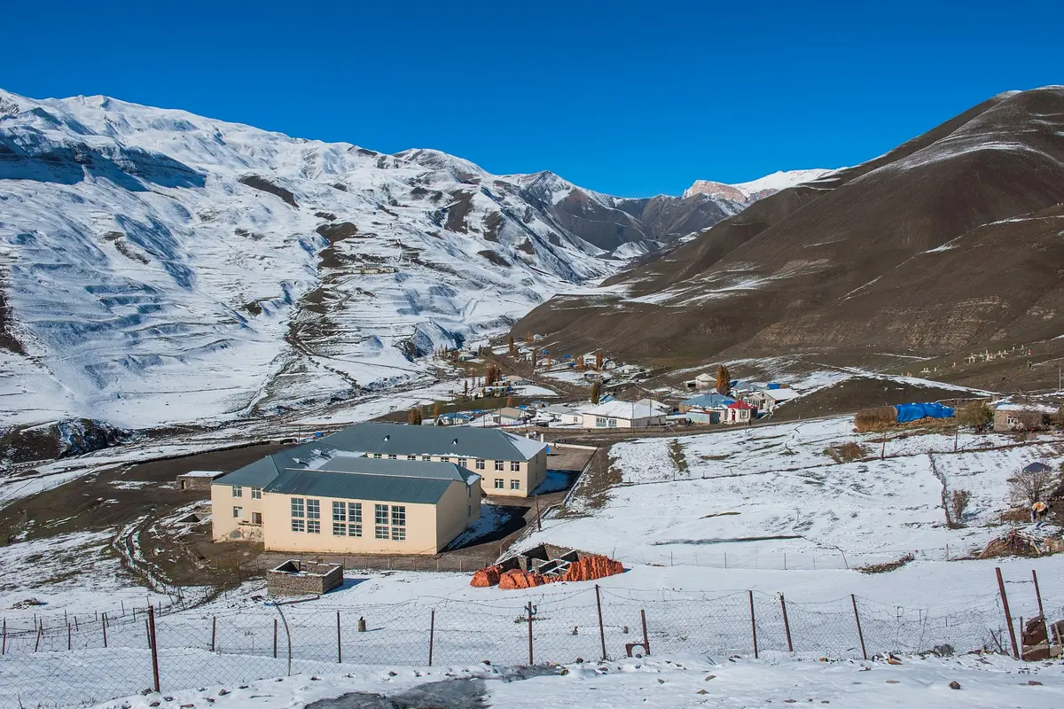 Un village de haute montagne du Caucase sous la neige fraîche et un ciel bleu profond