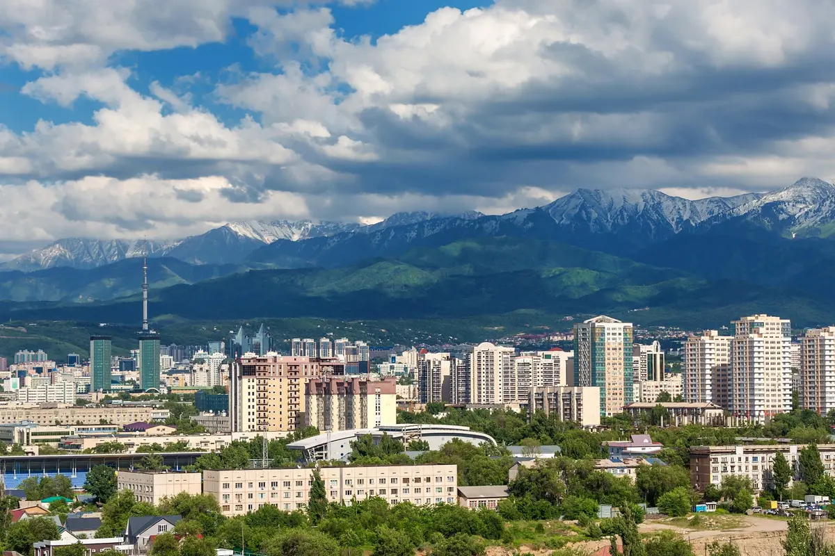 Skyline von Almaty mit Fernsehturm und den schneebedeckten Bergen des Transili-Alatau