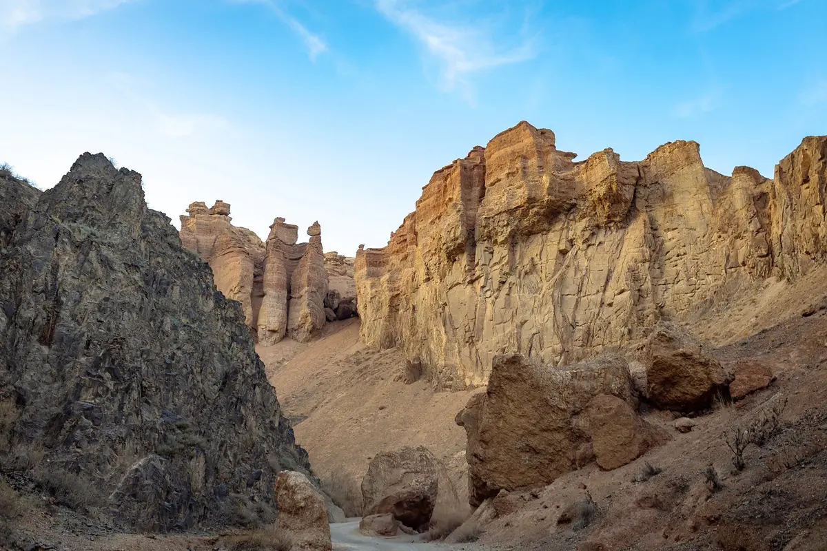 Hoch aufragende Sandsteinformationen und ein Erdweg im Tal der Burgen, Scharyn-Canyon
