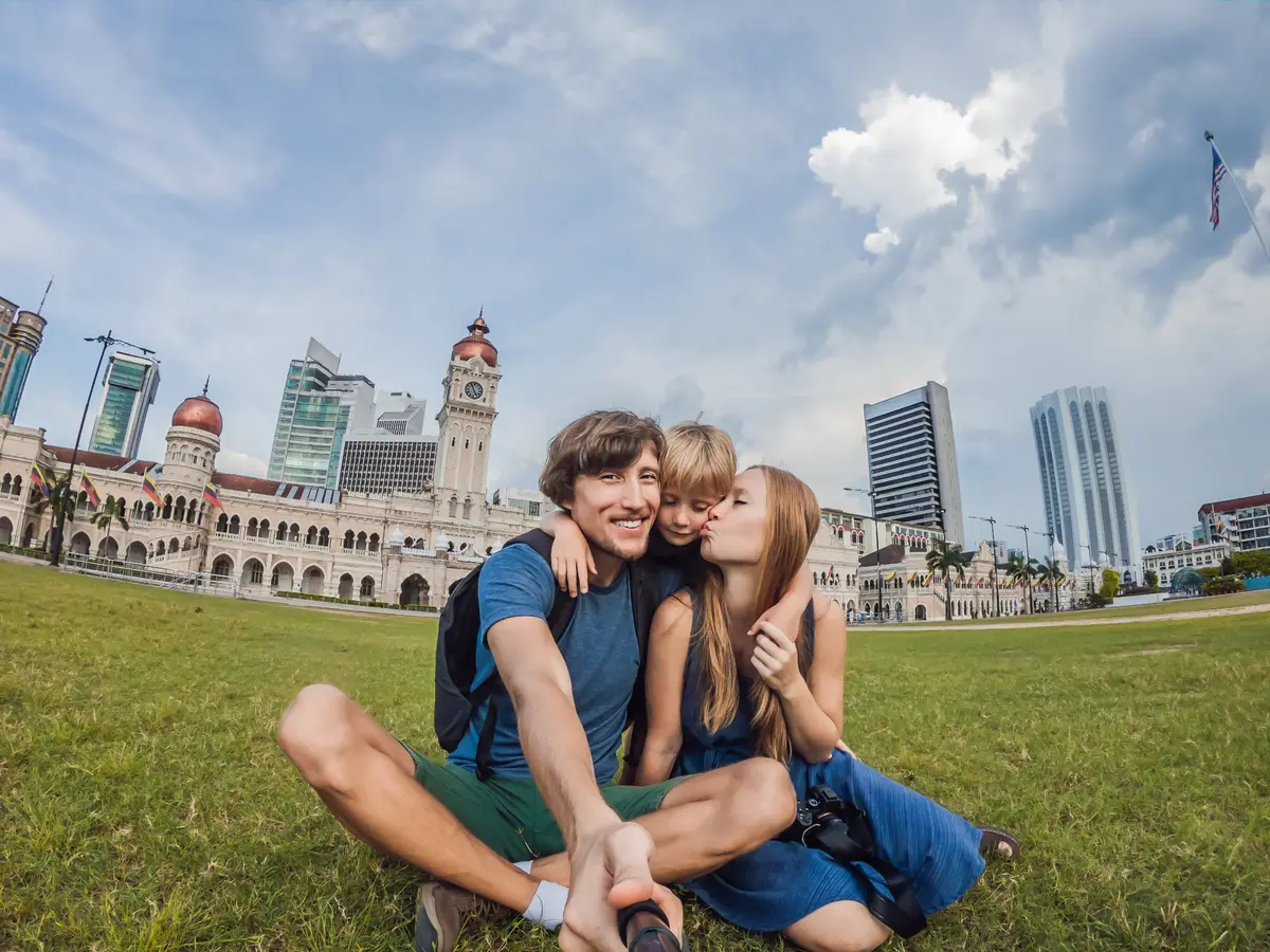 Une famille heureuse prend un selfie devant le bâtiment Sultan Abdul Samad, place Merdeka, à Kuala Lumpur