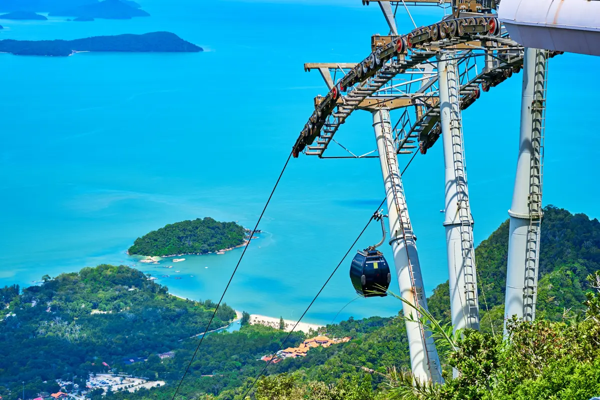 Une cabine de téléphérique sombre au-dessus d'une eau turquoise et de petites îles à Langkawi