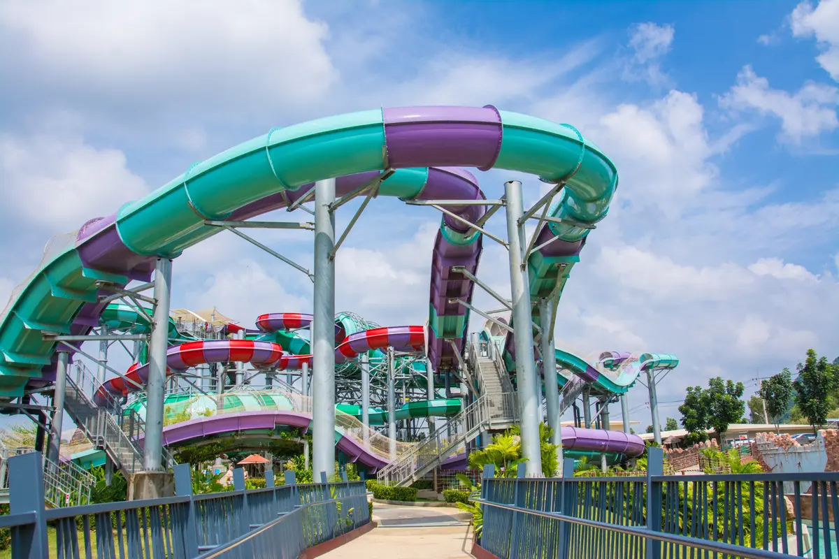 Des toboggans aquatiques colorés et sinueux sous un ciel bleu dans un parc aquatique
