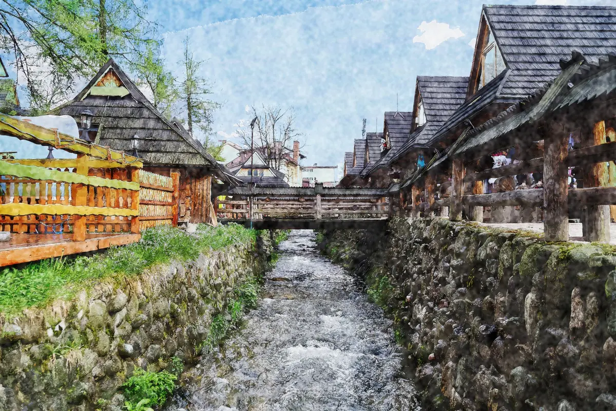 Ein Gebirgsbach zwischen Steinmauern und traditionellen Holzhäusern mit steilen Schindeldächern, vorn eine Holzbrücke (malerischer Bildeffekt)