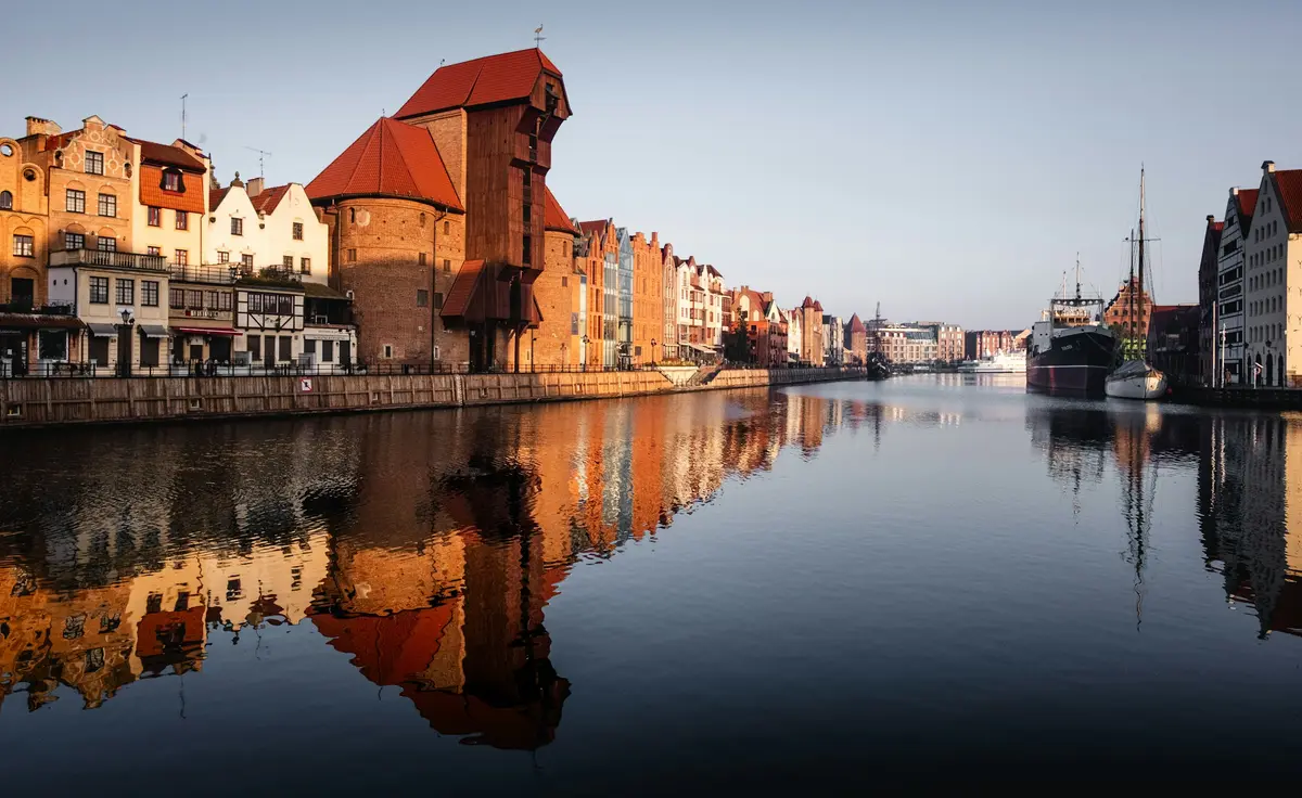 Historic waterfront buildings reflected in the river in Gdańsk, Poland