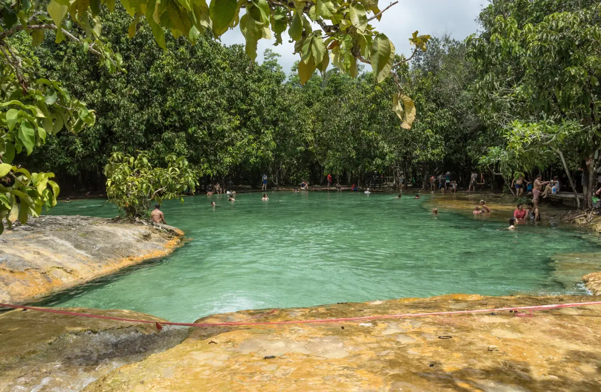 Ein smaragdgrünes Becken, von tropischen Bäumen umgeben, in Krabi, Besucher baden darin