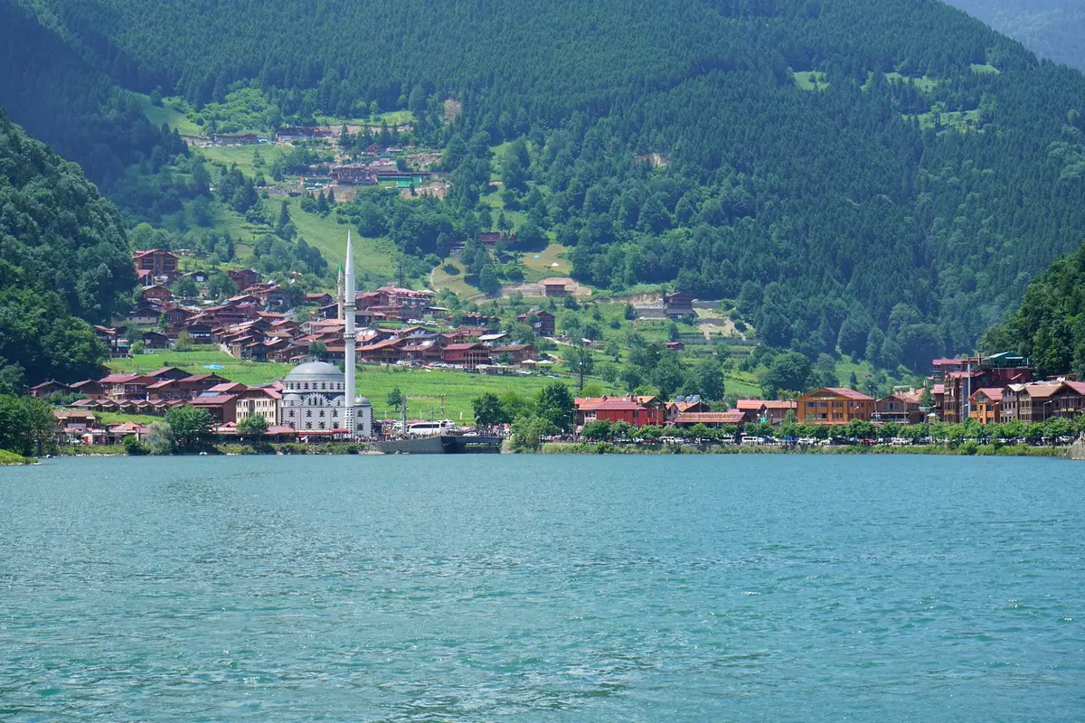 Der See Uzungöl mit Dorf und Moschee unter bewaldeten Hängen