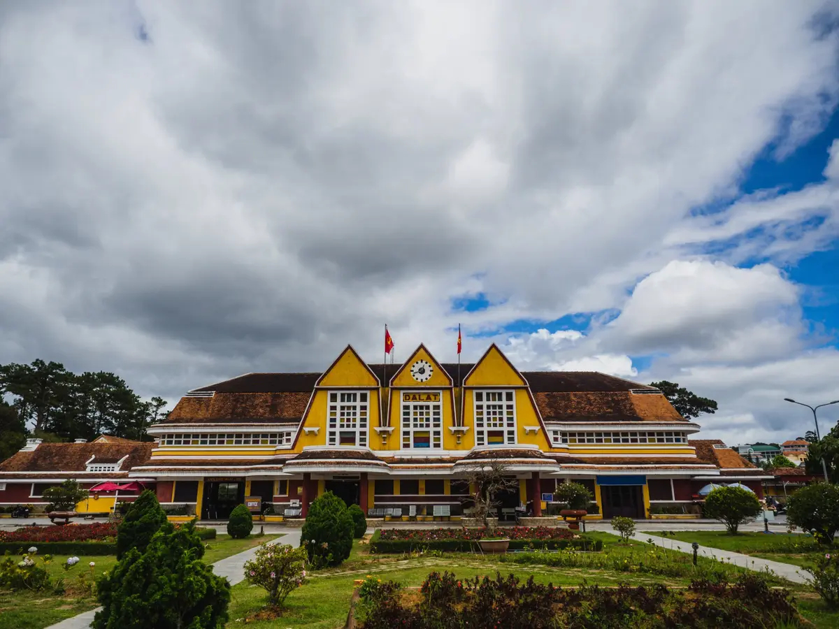Der historische Bahnhof von Dalat mit gelber Fassade und Gärten