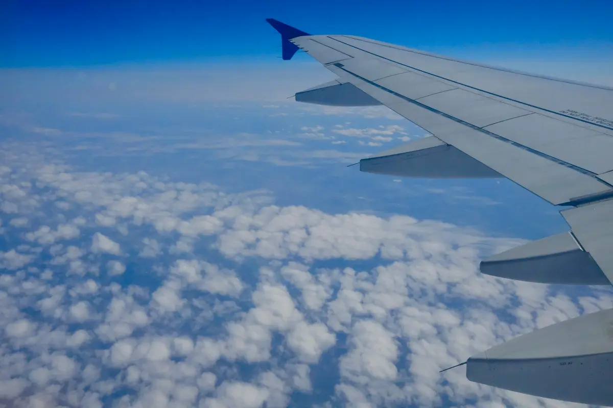 An aircraft wing above the clouds