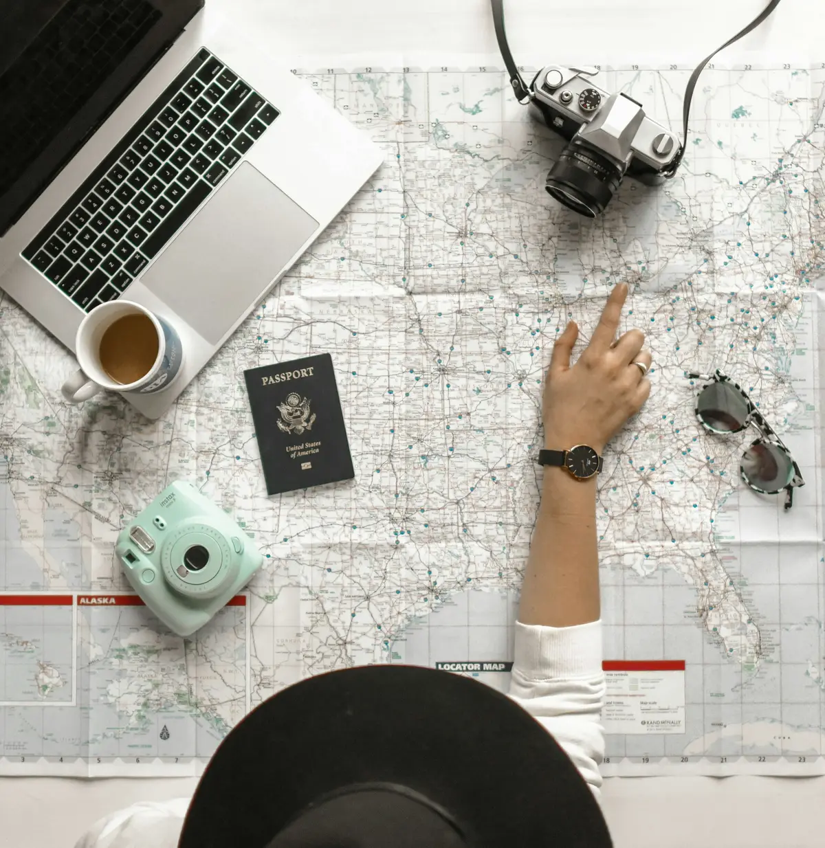 Passport, map and camera on a trip-planning table
